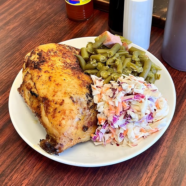 Blake's Barbecue grilled chicken with green beans and coleslaw on a white plate.